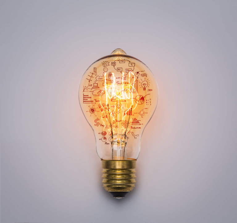 Illuminated light bulb with business concept doodles